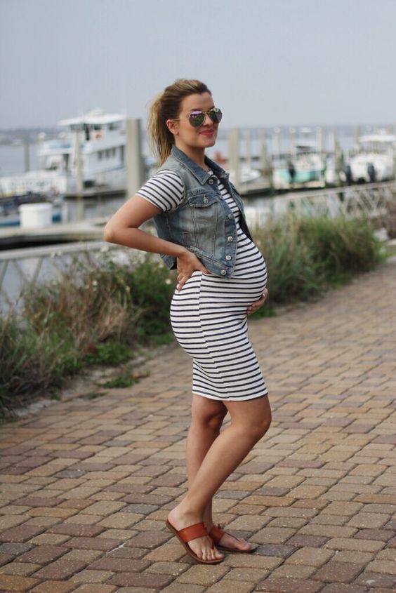 a striped black and white dress, a denim vest and brown leather sandals