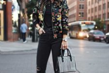 11 black ripped jeans, a black tee, a black floral print bomber jacket and white sneakers