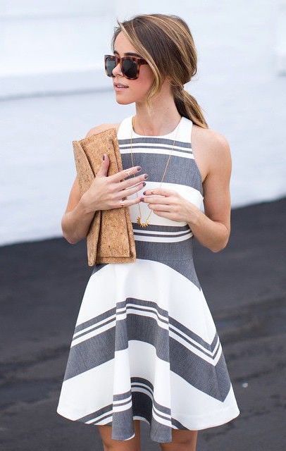 a grey and white striped halter neckline A-line dress and a neutral clutch