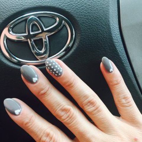 grey nails with polka dots and small hearts for accents