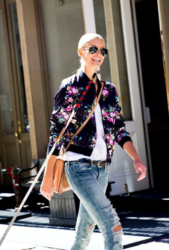 distressed jeans, a white shirt, a black floral print bomber jacket and a crossbody