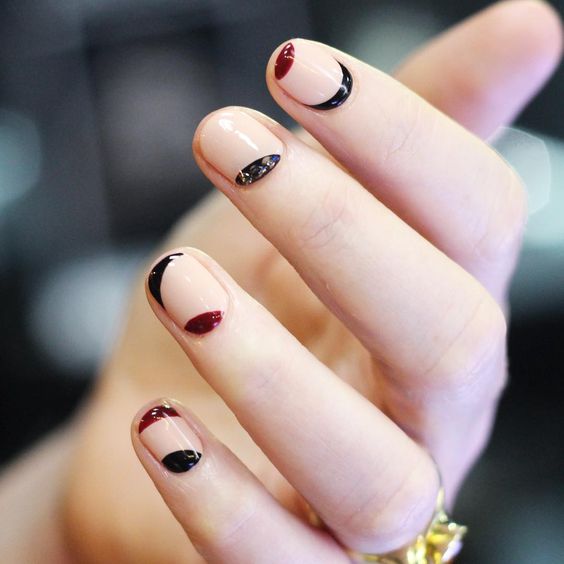 neutral round nails with black and red curves is a creative modern design