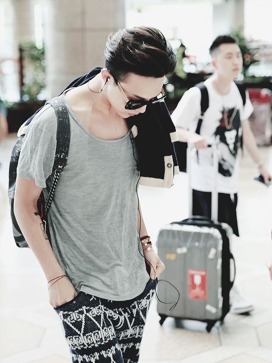 a loose grey tee, pinted black and white shorts and a backpack, relaxed rock style