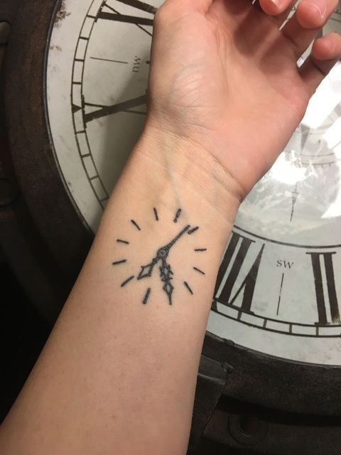 Black minimalistic tattoo on the wrist