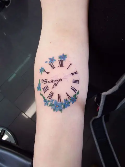 Clock with blue flowers tattoo