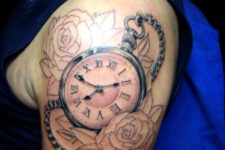Clock with two roses tattoo on the shoulder