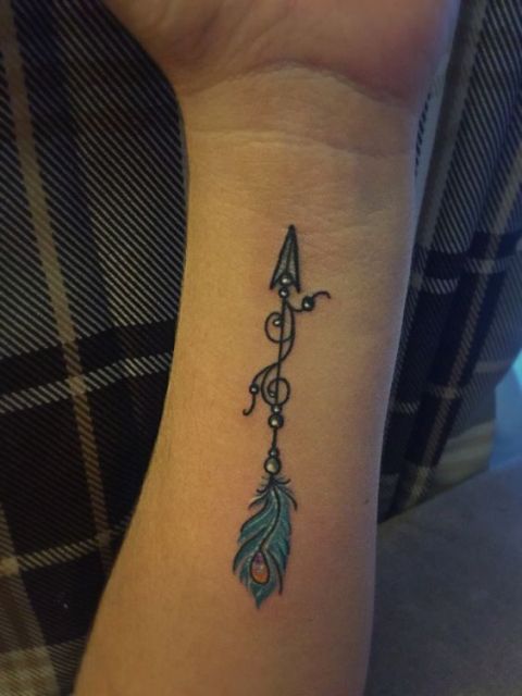 Feather with arrow tattoo on the arm