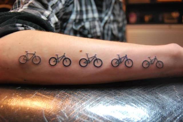 Five bicycles tattoo on the forearm