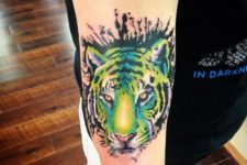 Green and yellow tiger tattoo on the hand
