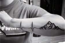 Heartbeat with mountain tattoo on the arm