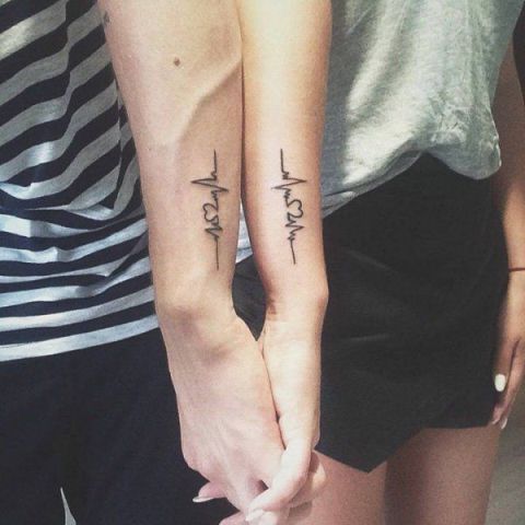 Matching heartbeat tattoos on the arms