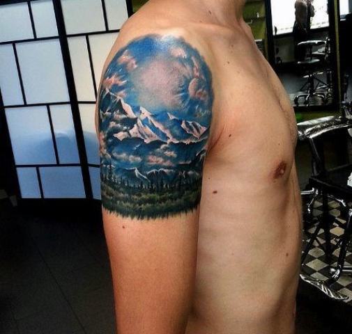Mountain with blue sky and green forest tattoo