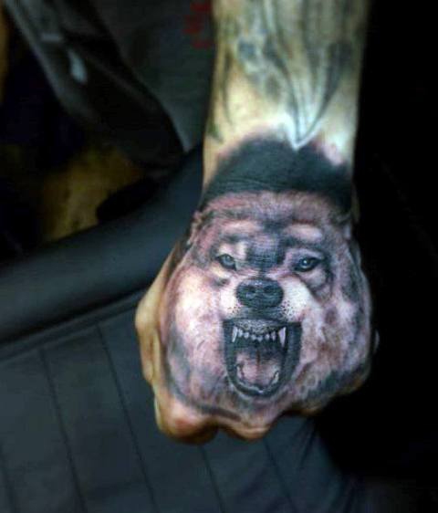 Realistic wolf tattoo on the hand