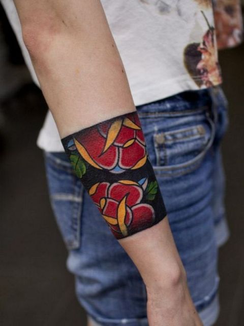 Tattoo with red flowers and green leaves