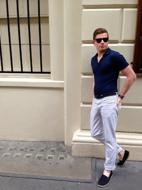 With navy blue shirt, white cuffed trousers and black belt