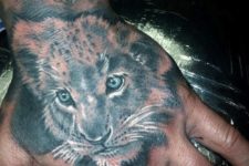 Young lion tattoo on the hand