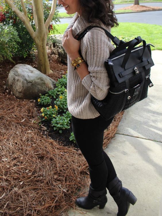 a neutral chunky knit sweater, black leggings, black booties and a black backpack