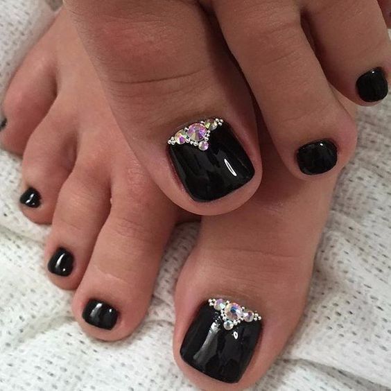 glossy black nails are a great choice for Halloween, accentuate them with rhinestones