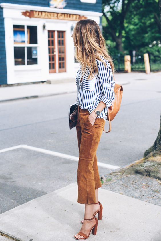 a striped white and black shirt, amber suede cropped pants, matching shoes and a backpack