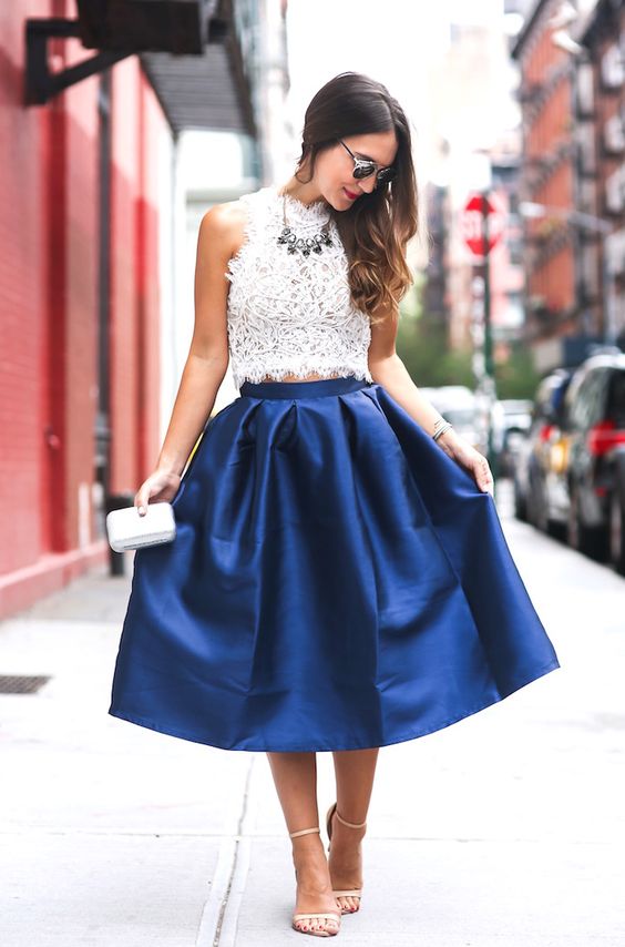 a sleeveless lace crop top, a statement necklace, a cobalt blue midi skirt, nude shoes