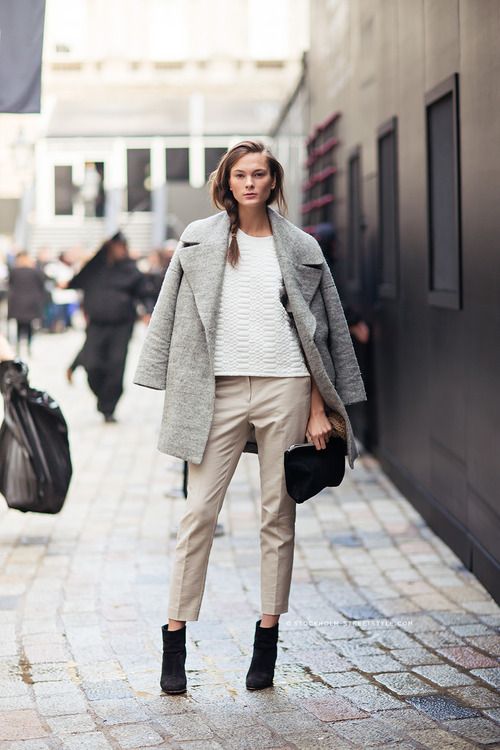 neutral cropped pants, black suede boots, a white textural top, a grey coat and a black clutch