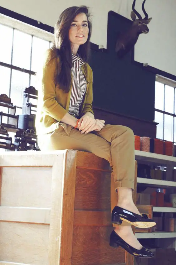 a black and white striped button-up shirt, a mustard cardigan, khaki trousers, low black heels