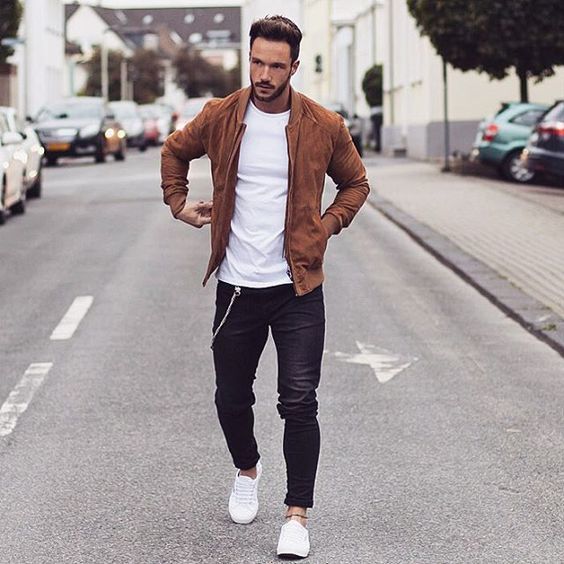 an amber suede bomber jacket, black jeans, a white tee and white sneakers