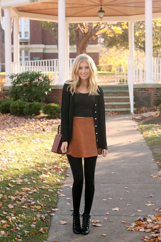 a fall outfit with a high waist orange skirt, a black crop top, a black cardigan, black tights and booties