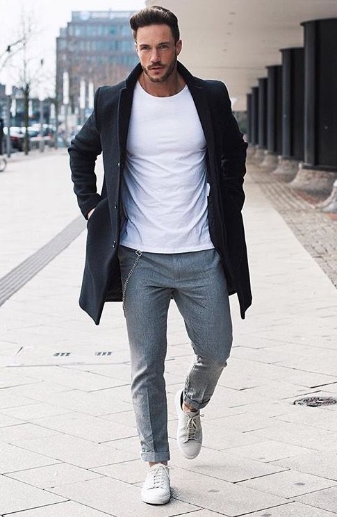 a white tee, grey pants, white sneakers and a black coat