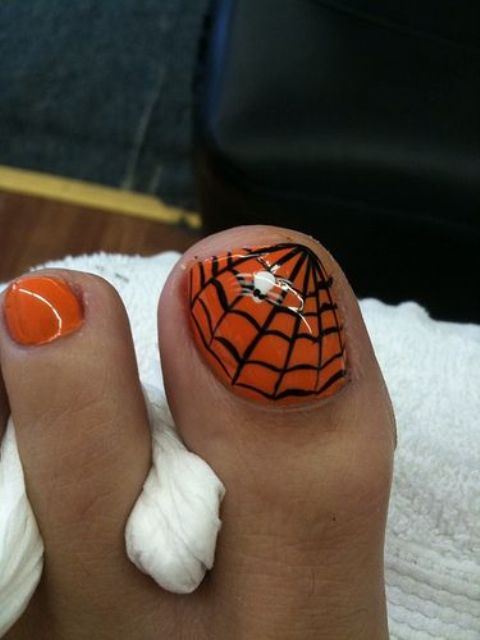 go for traditional Halloween colors   orange and black and paint a spider web on one of the nails