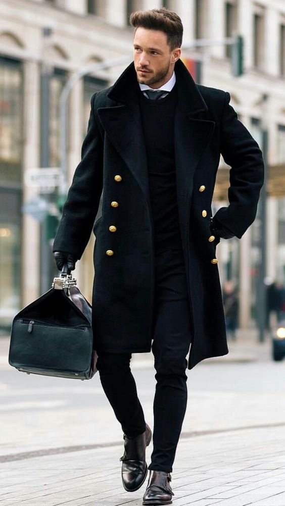 a total black look with jeans, boots and a double breasted coat
