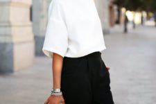 14 black pants, a white crop top with hald sleeves and black and white heels