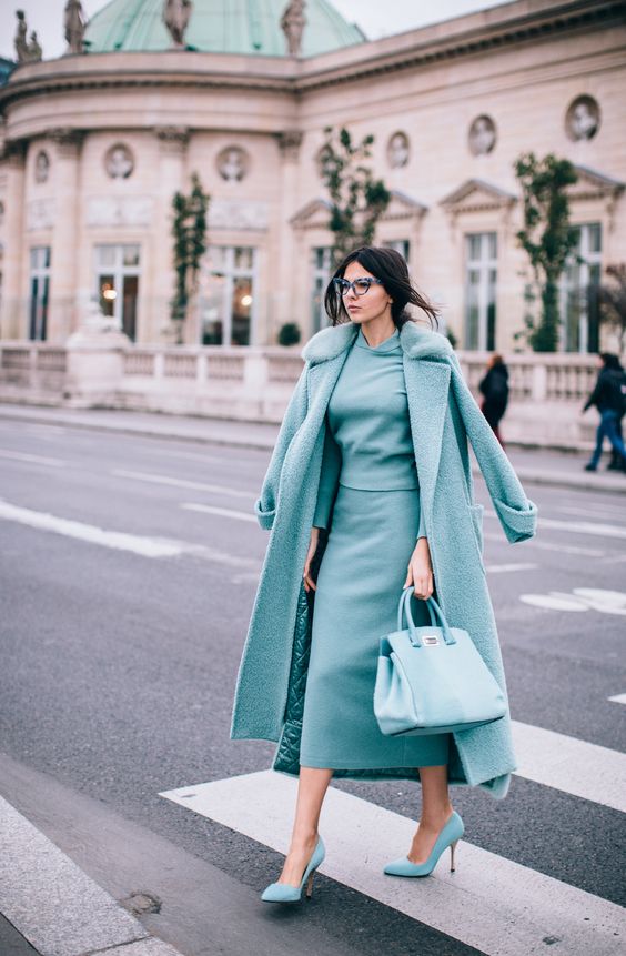 a grey suit with a top and a midi pencil skirt, a matching coat and blue shoes