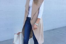 16 blue skinnies, a white top, a beige sleeveless coat and silver and black flats