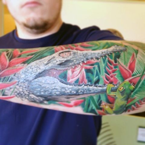 Alligator and frog tattoo on the forearm