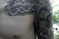 Black and white cloud tattoo on the shoulder and bicep