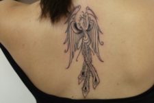 Black-contour phoenix tattoo on the back
