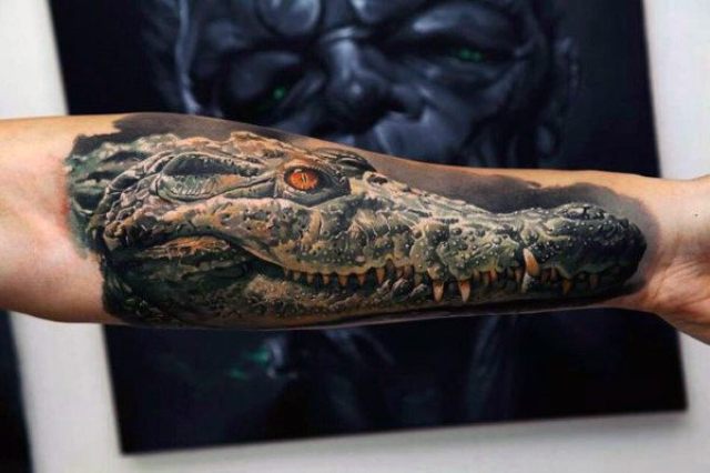 Dangerous alligator tattoo on the hand