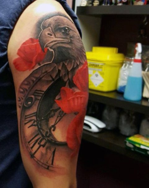 Eagle, clock and red flowers tattoo on the hand