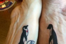 Matching penguin tattoos on the wrists