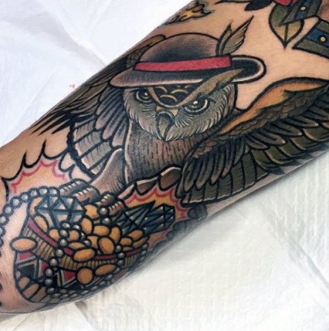 Owl with hat tattoo on the arm