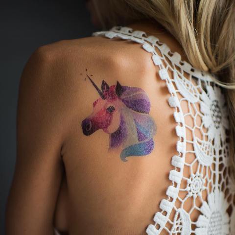 Pastel colored unicorn tattoo on the back