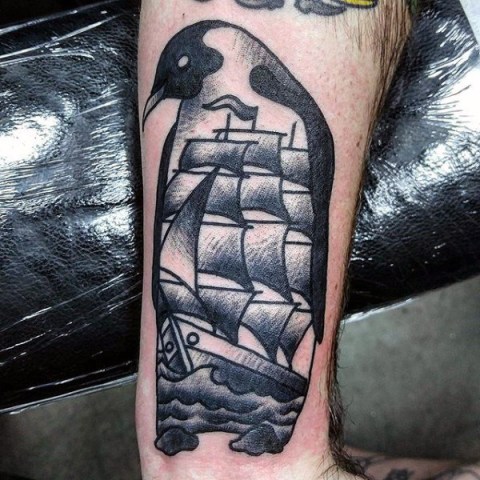 Penguin and ship tattoo on the leg
