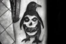 Penguin and skull tattoo on the wrist
