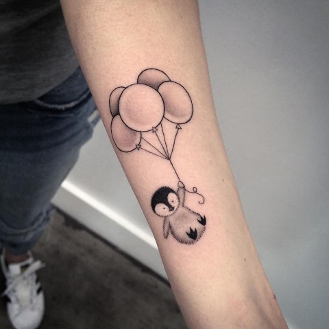 Pinguïn met ballonnen tatoeage op de arm