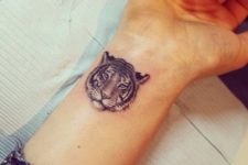 Small tiger head tattoo on the wrist