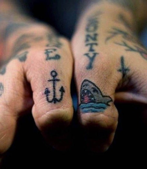Tiny shark and anchor tattoos on the fingers