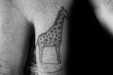 giraffe tattoo on a men’s finger