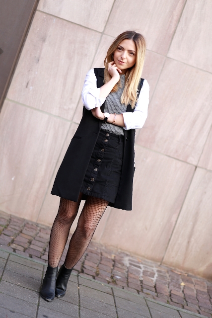 With gray shirt, black skirt, black ankle boots and cardigan