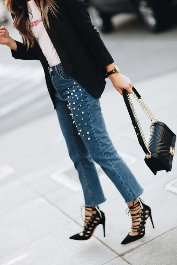 a printed tee, a black jacket, blue pearly jeans and black lace up shoes